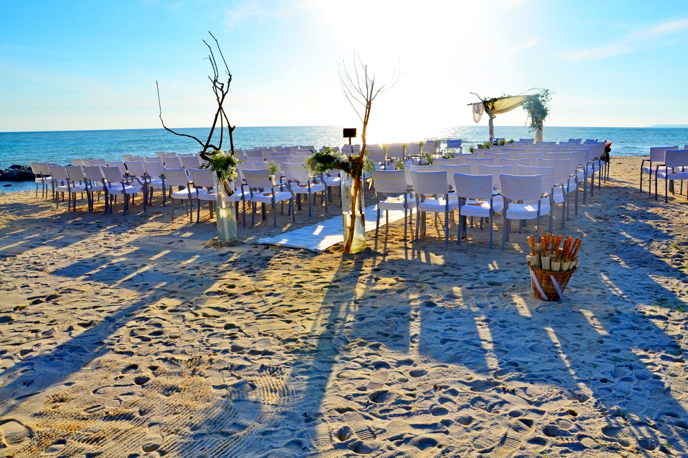 sedia a disposizione e altare sulla sabbia, con sfondo il mare