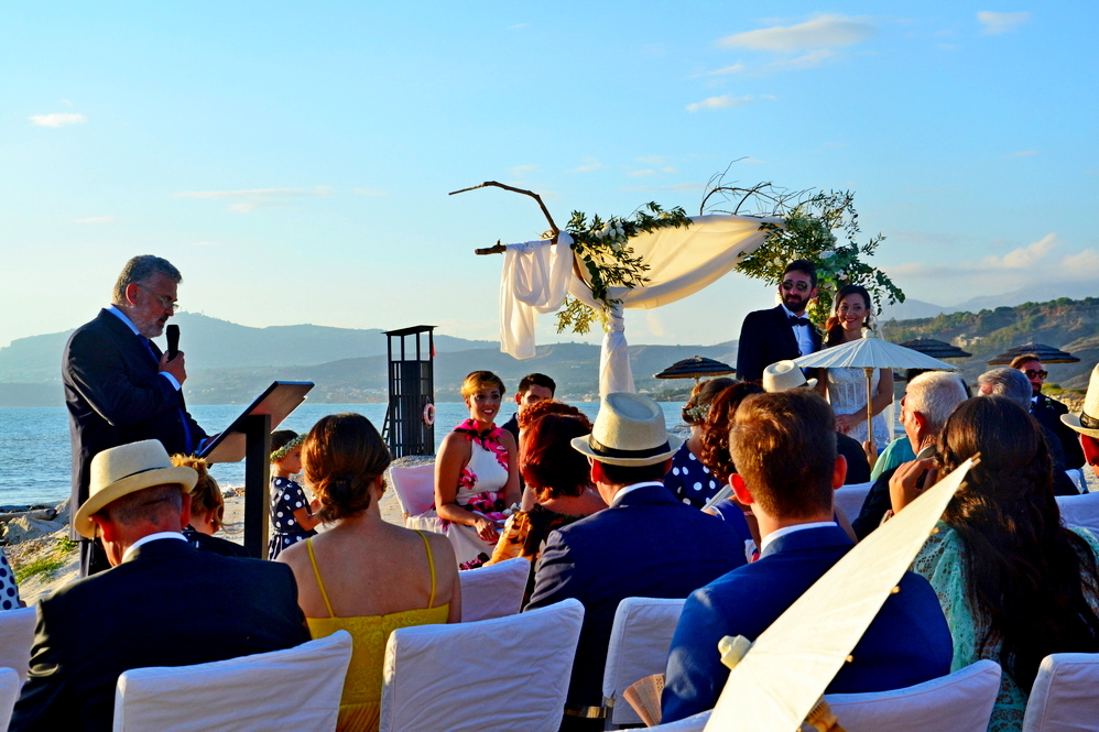 celebrazione di un matrimonio con persone sulla spiagge e sfondo il mare
